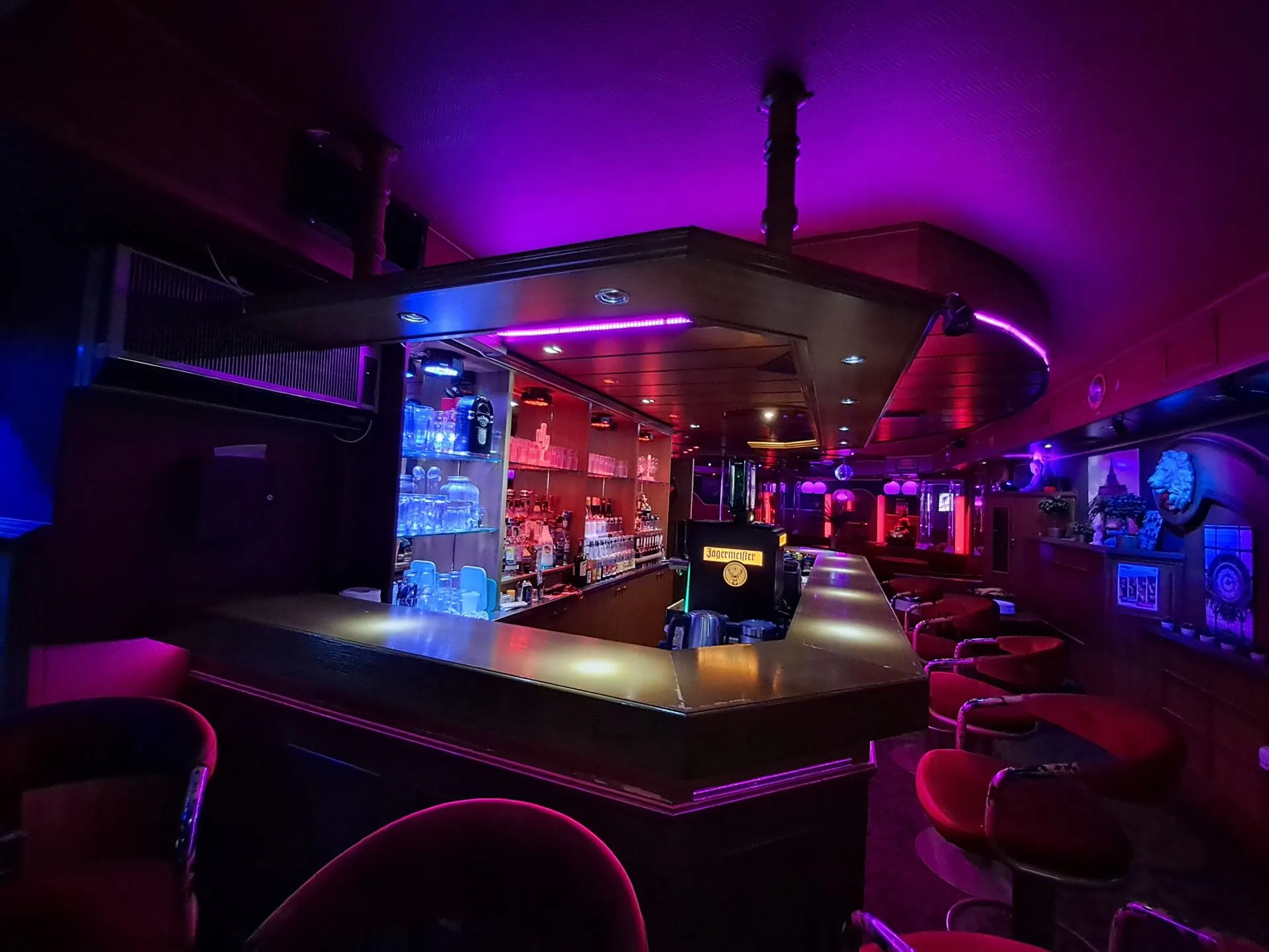 Corner of the bar counter with stools in purple half-light