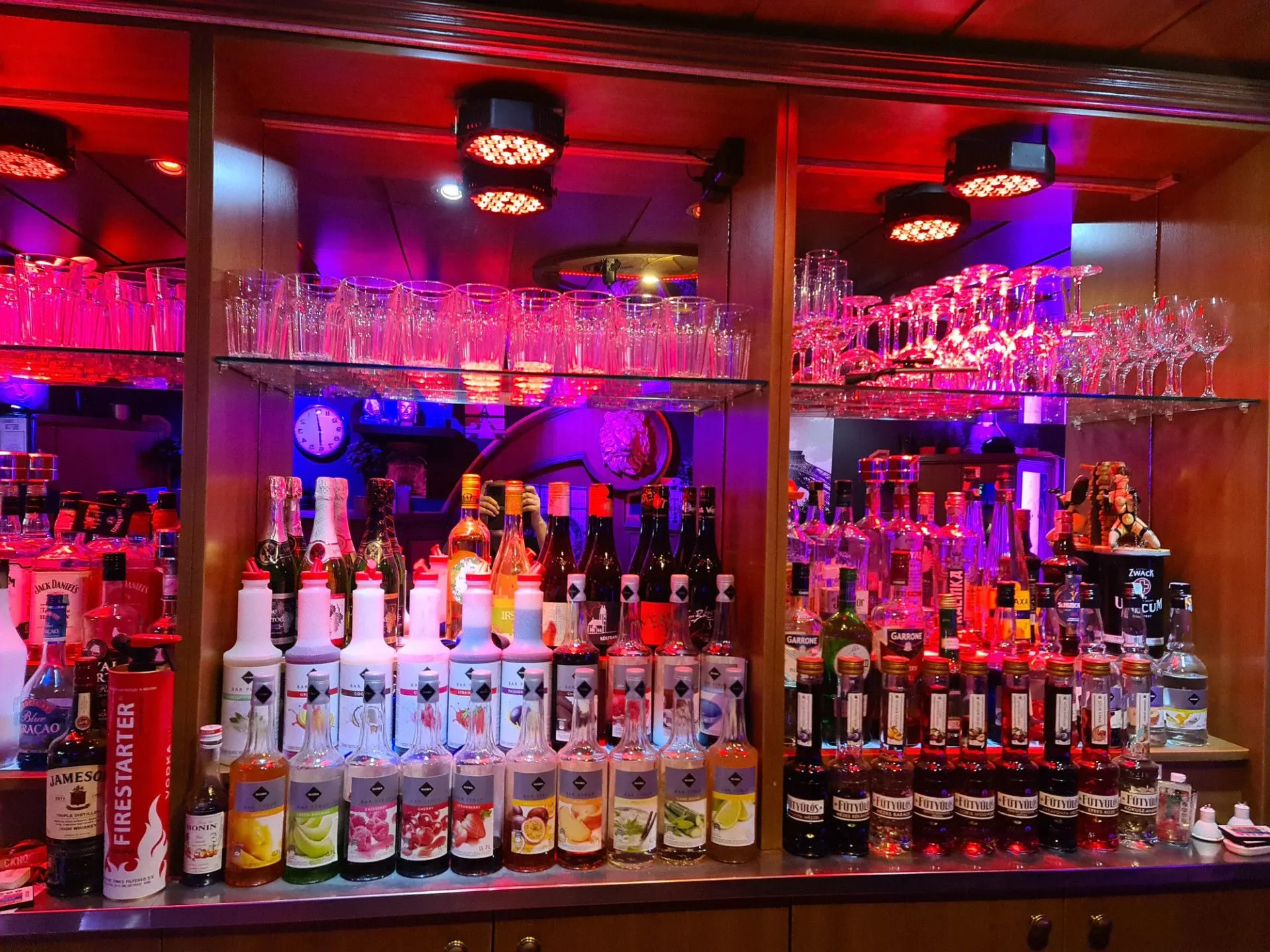 Close-up of the bar’s drinks selection under red light
