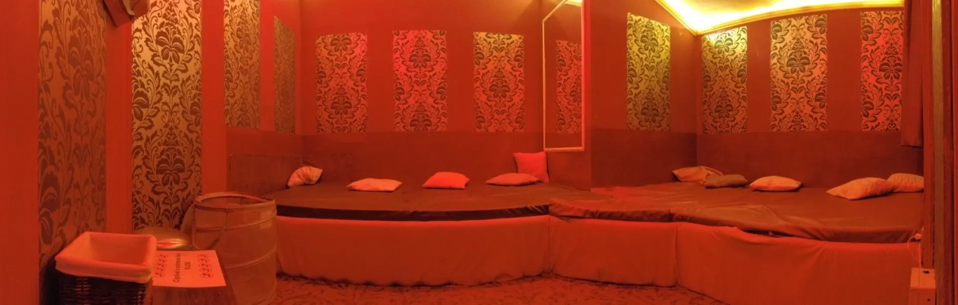 Room with a large bed and patterned wallpaper in warm light