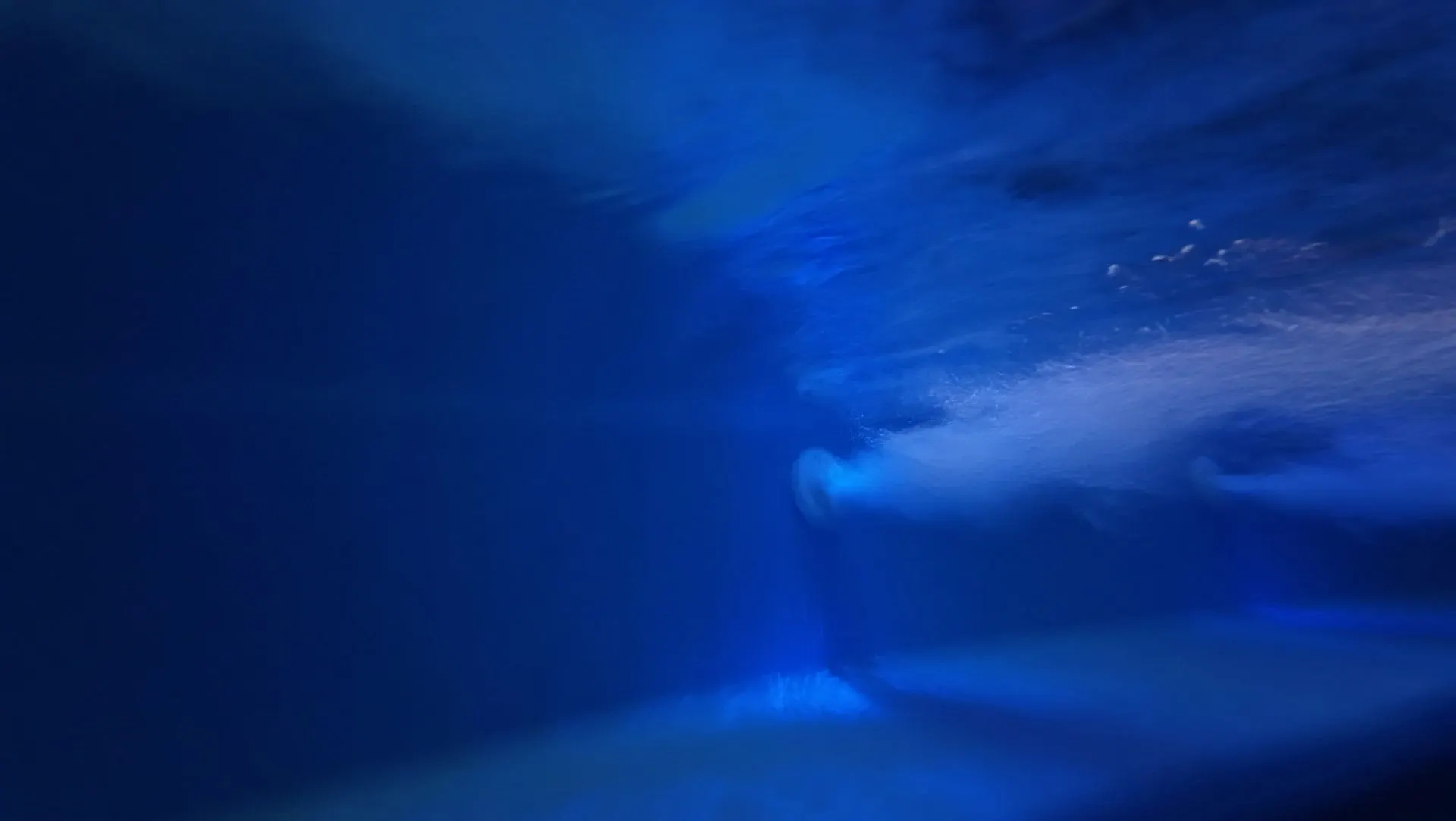 Underwater view with bubbles in the jacuzzi’s blue water