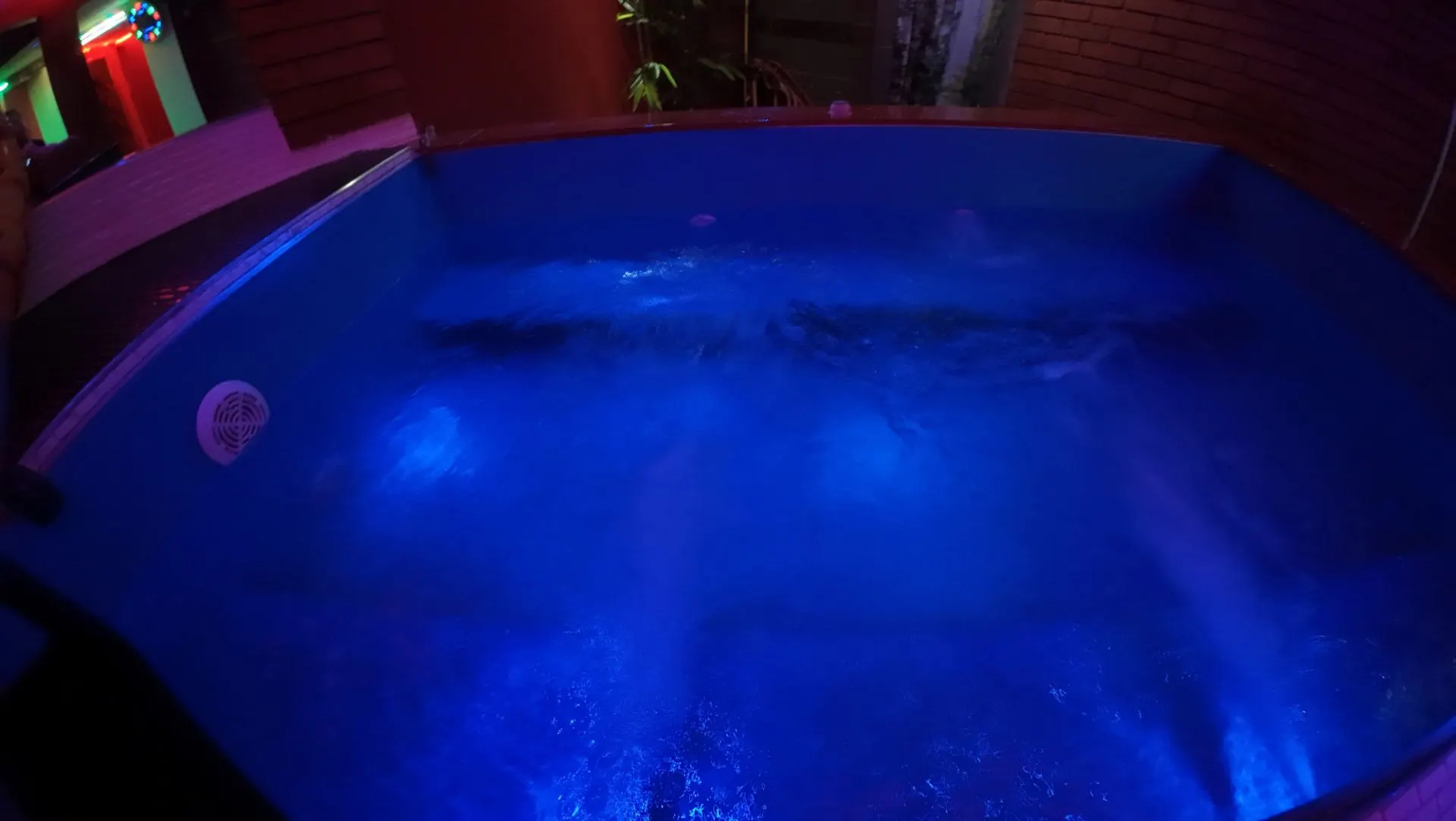 The jacuzzi from above with glowing blue water at night
